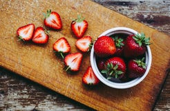 Fragole affettate deliziose su una tavola di legno d'annata fotografie stock libere da diritti Fragole affettate deliziose su una tavola di legno d'annata fotografie stock libere da diritti