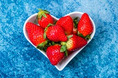 Fragole in un piatto in forma di cuore bianco fotografia stock Fragole in un piatto in forma di cuore bianco fotografia stock