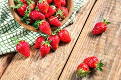Fraise mûre fraîche organique sur une table en bois de vieux vintage Des baies sont versées d'une cuvette en bois sur un fond Image stock Fraise mûre fraîche organique sur une table en bois de vieux vintage Des baies sont versées d'une cuvette en bois sur un fond Image stock