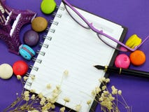 Francuscy macaroons z wysuszonym kwiatem i pustym notatnikiem wzywają tło obraz royalty free Francuscy macaroons z wysuszonym kwiatem i pustym notatnikiem wzywają tło obraz royalty free