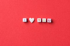 Frase ti amo fatta dai cubi della lettera e dalla singola forma Sugar Candy Sprinkle bianco del cuore su fondo rosso scuro valent immagine stock libera da diritti Frase ti amo fatta dai cubi della lettera e dalla singola forma Sugar Candy Sprinkle bianco del cuore su fondo rosso scuro valent immagine stock libera da diritti