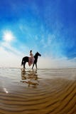 Frau auf einem Pferd durch das Meer stockfotos Frau auf einem Pferd durch das Meer stockfotos