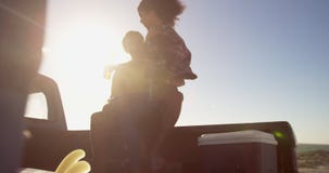 Frau bemannt an den Schoss, der auf einem Kleintransporter am Strand 4k sitzt stock footage Frau bemannt an den Schoss, der auf einem Kleintransporter am Strand 4k sitzt stock footage