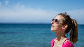 Frau, die das Meer genießt den sonnigen Tag bereitsteht lizenzfreie stockbilder Frau, die das Meer genießt den sonnigen Tag bereitsteht lizenzfreie stockbilder