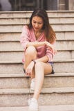 Frau, die an der Leiter sitzt lizenzfreies stockbild Frau, die an der Leiter sitzt lizenzfreies stockbild
