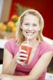 Frau, die einen BeereSmoothie trinkt lizenzfreie stockbilder Frau, die einen BeereSmoothie trinkt lizenzfreie stockbilder