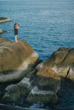 Frau, die Foto von schönem blauem Meer von der Klippe macht stockbild Frau, die Foto von schönem blauem Meer von der Klippe macht stockbild