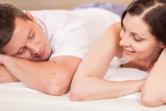 Frau, die Mann betrachtet und im Bett liegt stockbilder Frau, die Mann betrachtet und im Bett liegt stockbilder