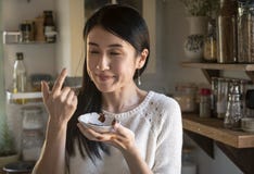 Frau, die Schokoladensoße von einer Schale schmeckt stockfotografie Frau, die Schokoladensoße von einer Schale schmeckt stockfotografie