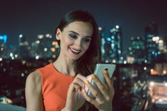 Frau, die Telefon für Social Media in der städtischen Landschaft verwendet lizenzfreie stockbilder Frau, die Telefon für Social Media in der städtischen Landschaft verwendet lizenzfreie stockbilder