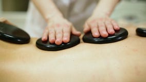 Frau, die Warmsteinmassage am Badekurort genießend sich entspannt stock video footage Frau, die Warmsteinmassage am Badekurort genießend sich entspannt stock video footage