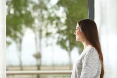 Frau, die zu Hause Außenseite durch Fenster schaut lizenzfreies stockbild Frau, die zu Hause Außenseite durch Fenster schaut lizenzfreies stockbild