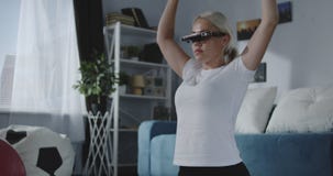 Frau, die zu Hause mit VR-Kopfhörer ausarbeitet Frau, die zu Hause mit VR-Kopfhörer ausarbeitet