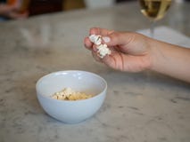 Frau manikürte Hand, die frisches Popcorn aus einer kleinen Schüssel mit Wein heraus ergreift stockfotos Frau manikürte Hand, die frisches Popcorn aus einer kleinen Schüssel mit Wein heraus ergreift stockfotos