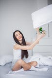 Frau mit Ballon auf Schwarzem Eine schöne junge lächelnde Brunettefrau bequem und, die himmlisch im weißen Bett liegt lizenzfreie stockbilder Frau mit Ballon auf Schwarzem Eine schöne junge lächelnde Brunettefrau bequem und, die himmlisch im weißen Bett liegt lizenzfreie stockbilder