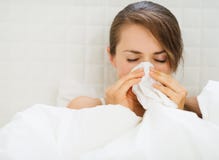 Frau mit der Grippe, die in Bett legt lizenzfreies stockfoto Frau mit der Grippe, die in Bett legt lizenzfreies stockfoto
