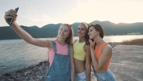 Frau mit drei Freunden, die Selbstporträtfoto mit Smartphone lächelt und macht stock footage Frau mit drei Freunden, die Selbstporträtfoto mit Smartphone lächelt und macht stock footage