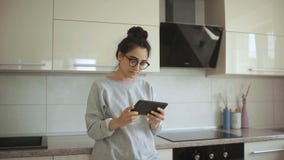 Frau passt Komödien-Film auf Tablet an der Küche auf stock video Frau passt Komödien-Film auf Tablet an der Küche auf stock video