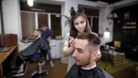 Frau und Mann, die den männlichen Kunden im Salon klassisches stilvolles Haar herstellen stock footage Frau und Mann, die den männlichen Kunden im Salon klassisches stilvolles Haar herstellen stock footage