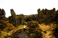 Frau wandert durch Lavabildungen in Island lizenzfreie stockfotografie Frau wandert durch Lavabildungen in Island lizenzfreie stockfotografie