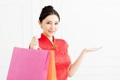 Frau, welche die Einkaufstaschen zeigt und etwas vorstellt Lizenzfreie Stockfotos Frau, welche die Einkaufstaschen zeigt und etwas vorstellt Lizenzfreie Stockfotos