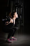 Frauen-Gewicht-Training an der Gymnastik Anhebende Gewichte des gewidmeten Bodybuildermädchens in der Turnhalle und im Handeln de lizenzfreies stockbild Frauen-Gewicht-Training an der Gymnastik Anhebende Gewichte des gewidmeten Bodybuildermädchens in der Turnhalle und im Handeln de lizenzfreies stockbild