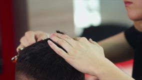 Frauenfriseur, der dem jungen Mann Haarschnitt macht Sie unter Verwendung der Scheren und des Kammes stock footage Frauenfriseur, der dem jungen Mann Haarschnitt macht Sie unter Verwendung der Scheren und des Kammes stock footage