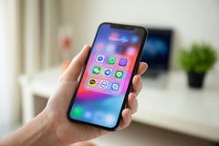 Frauenhand, die iPhone X mit Social Networking Boten hält Frauenhand, die iPhone X mit Social Networking Boten hält