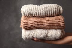Frauenholdingstapel gefaltete warme gestrickte Strickjacken stockbild Frauenholdingstapel gefaltete warme gestrickte Strickjacken stockbild