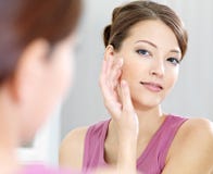 Fraueninteressieren ihrer schönen Haut auf dem Gesicht lizenzfreies stockbild Fraueninteressieren ihrer schönen Haut auf dem Gesicht lizenzfreies stockbild