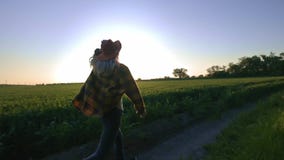 Frauenlandwirt läuft entlang die Straße entlang dem Feld Glaubt einer Richtung der Freiheit von der Stadt und vom Geschäft Herein stock footage Frauenlandwirt läuft entlang die Straße entlang dem Feld Glaubt einer Richtung der Freiheit von der Stadt und vom Geschäft Herein stock footage