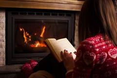 Frauenlesung durch den Kamin lizenzfreies stockfoto Frauenlesung durch den Kamin lizenzfreies stockfoto