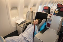 Frauenpassagier, der an der Business-Class des Flugzeuges schläft lizenzfreies stockfoto Frauenpassagier, der an der Business-Class des Flugzeuges schläft lizenzfreies stockfoto