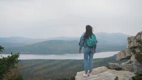 Frauentourist auf die Oberseite ist glücklich feiernd und Erfolg Eine Frau in einer Denimjacke auf die Welt freut sich in a stock video Frauentourist auf die Oberseite ist glücklich feiernd und Erfolg Eine Frau in einer Denimjacke auf die Welt freut sich in a stock video