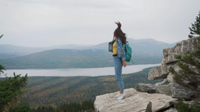 Frauentourist auf die Oberseite ist glücklich feiernd und Erfolg Eine Frau in einer Denimjacke auf die Welt freut sich in a stock video footage Frauentourist auf die Oberseite ist glücklich feiernd und Erfolg Eine Frau in einer Denimjacke auf die Welt freut sich in a stock video footage