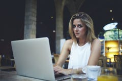 Freelancer de sexo femenino que usa el red-libro para el trabajo de la distancia durante el desayuno de la mañana en café imagenes de archivo Freelancer de sexo femenino que usa el red-libro para el trabajo de la distancia durante el desayuno de la mañana en café imagenes de archivo
