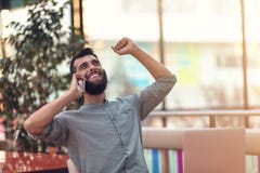 Freelancer farpado feliz entusiasmado que lê o e-mail com resultados sobre a vitória na competição em linha moderna que senta-se fotografia de stock Freelancer farpado feliz entusiasmado que lê o e-mail com resultados sobre a vitória na competição em linha moderna que senta-se fotografia de stock