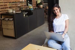 Freelancer fêmea lindo que usa o rede-livro para o trabalho da distância ao sentar-se na cafetaria moderna fotos de stock Freelancer fêmea lindo que usa o rede-livro para o trabalho da distância ao sentar-se na cafetaria moderna fotos de stock