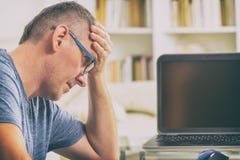 Freelancerman på arbetsplatsen i regeringsställning som rymmer hans huvud på händer Fotografering för Bildbyråer Freelancerman på arbetsplatsen i regeringsställning som rymmer hans huvud på händer Fotografering för Bildbyråer