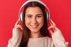 Freestyle. Young woman in headphones standing isolated on red listening music smiling toothy to camera close-up royalty free stock photo Freestyle. Young woman in headphones standing isolated on red listening music smiling toothy to camera close-up royalty free stock photo