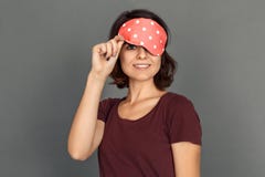Freestyle. Young woman in sleeping mask isolated on grey looking camera cheerful royalty free stock images Freestyle. Young woman in sleeping mask isolated on grey looking camera cheerful royalty free stock images