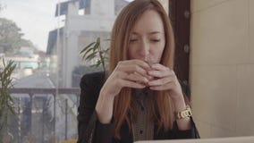 Freiberuflerarbeitskraftfrau sitzt im Café mit dem Laptop und Arbeiten und nippt an Tee stock video Freiberuflerarbeitskraftfrau sitzt im Café mit dem Laptop und Arbeiten und nippt an Tee stock video