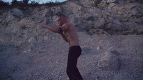 Freier Kämpfer, der auf dem rauen Felsen und dem ausbildenden freien Kampf rüttelt 4K stock footage Freier Kämpfer, der auf dem rauen Felsen und dem ausbildenden freien Kampf rüttelt 4K stock footage