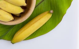 Fresh banana in a wooden bowl with a green banana leaf on white royalty free stock photography Fresh banana in a wooden bowl with a green banana leaf on white royalty free stock photography