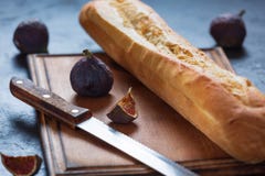 FRESH CRUNCHING BAGUETTE AND FIGS IN CLOSEUP ON TABLE