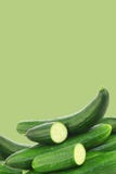 Fresh cucumbers and some cut pieces. On a green background royalty free stock photography Fresh cucumbers and some cut pieces. On a green background royalty free stock photography