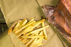 Fresh fried French fries and salmon on wooden background. A textured background.Copy paste place stock photo Fresh fried French fries and salmon on wooden background. A textured background.Copy paste place stock photo