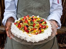 Fresh fruit pavlova on glass tray held by chef royalty free stock image Fresh fruit pavlova on glass tray held by chef royalty free stock image