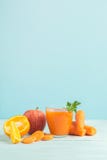 Fresh juice from carrots and orange apples in a glass on a wooden blue background. Selective focus. Copy space. royalty free stock photos Fresh juice from carrots and orange apples in a glass on a wooden blue background. Selective focus. Copy space. royalty free stock photos