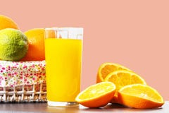 Fresh orange juice in a glass beaker, slices of sliced oranges and basket with oranges isolated on a pink background stock image Fresh orange juice in a glass beaker, slices of sliced oranges and basket with oranges isolated on a pink background stock image